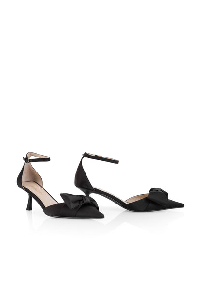 Black high-heeled shoes with bow details on a white background