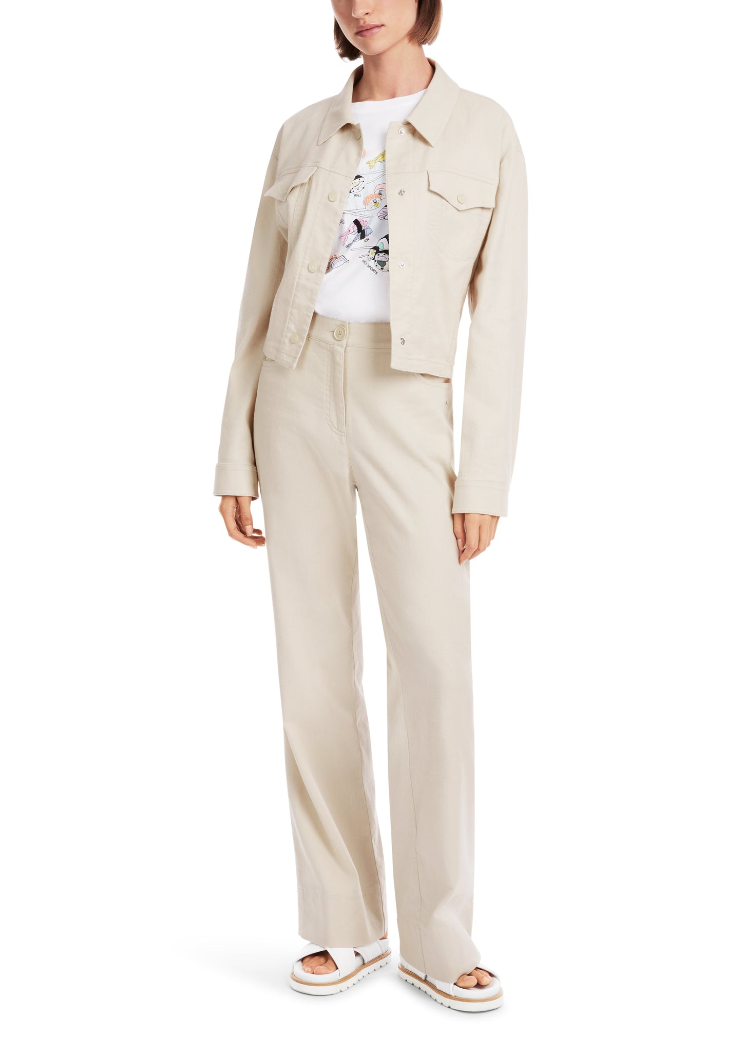 Woman wearing a beige jacket and pants set on a white background