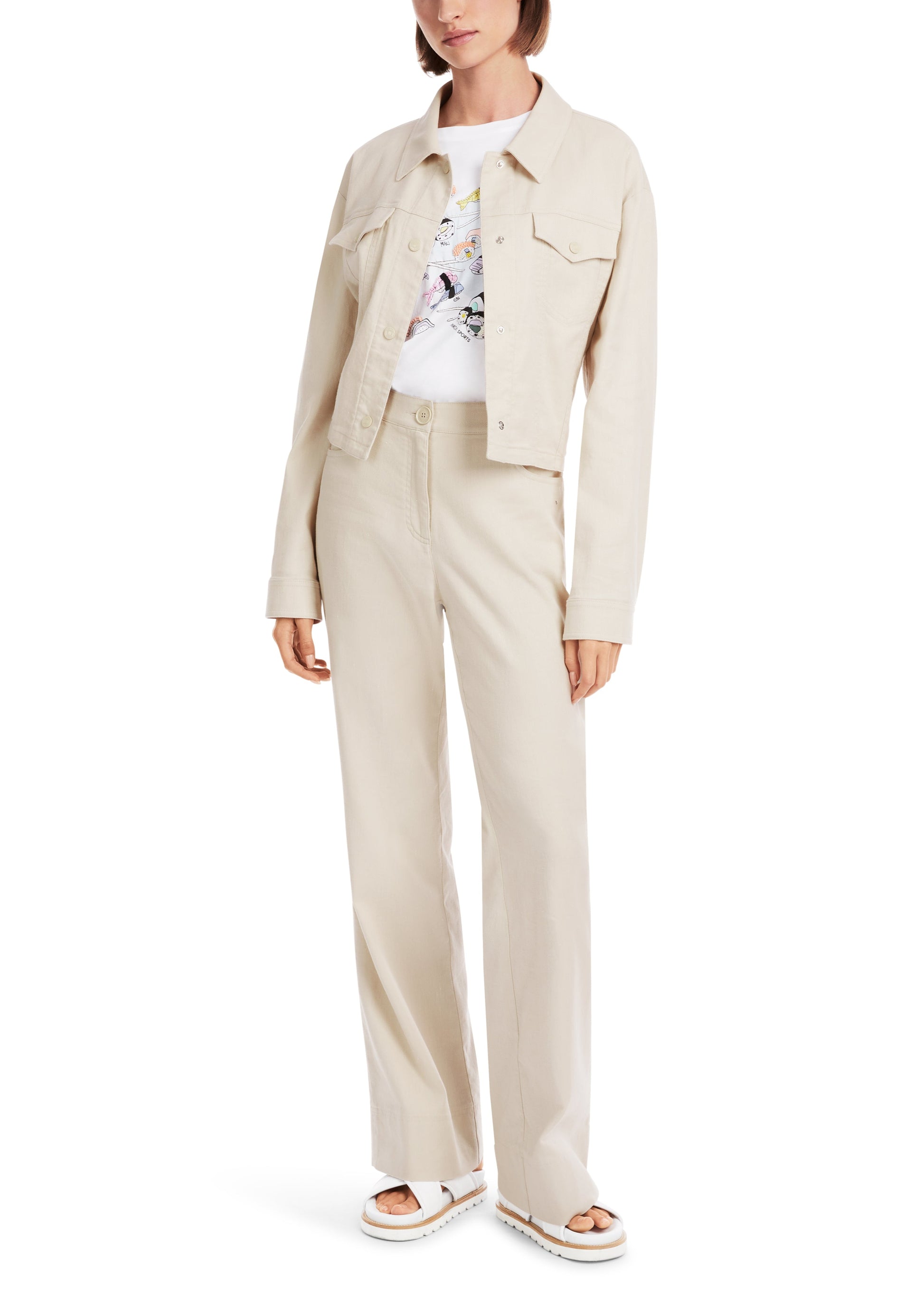 Woman wearing a beige jacket and pants set on a white background