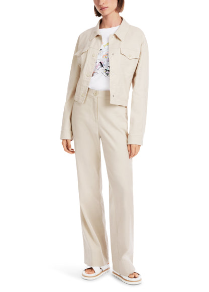 Woman wearing a beige jacket and pants set on a white background