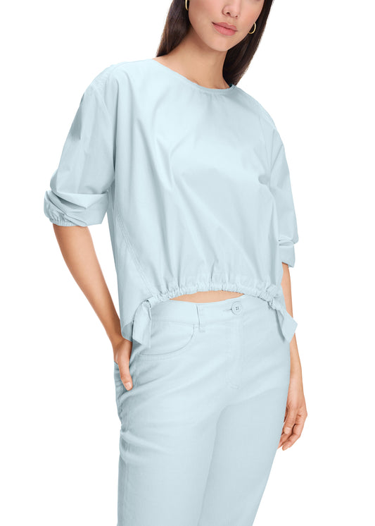 Woman wearing a light blue outfit on a white background