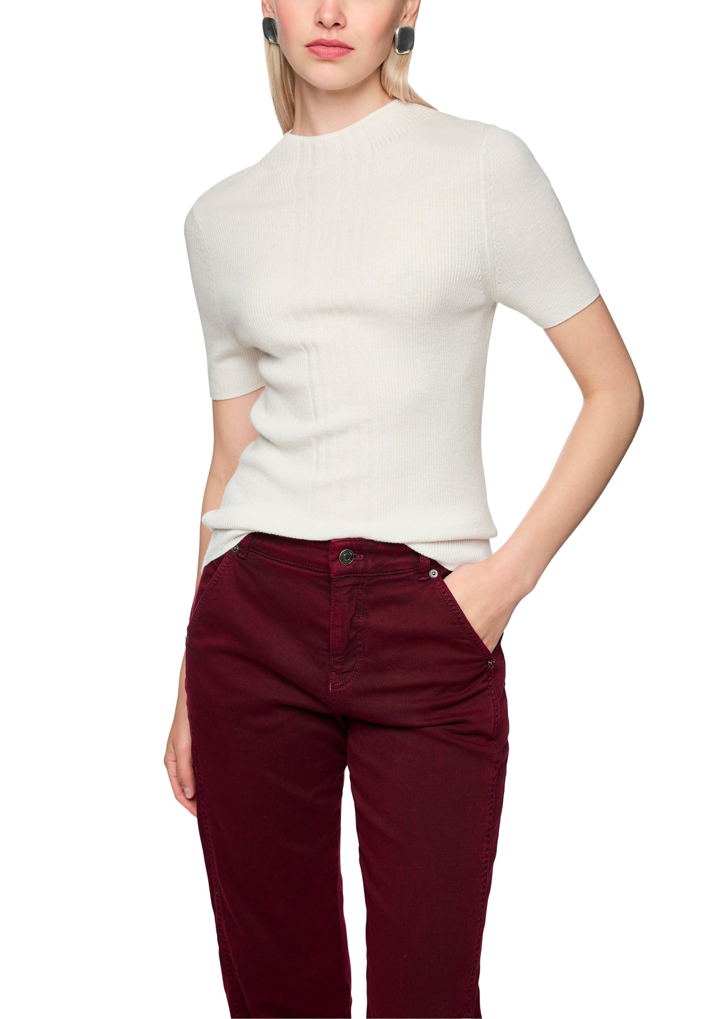 Person wearing a white short-sleeve shirt and burgundy pants on a white background