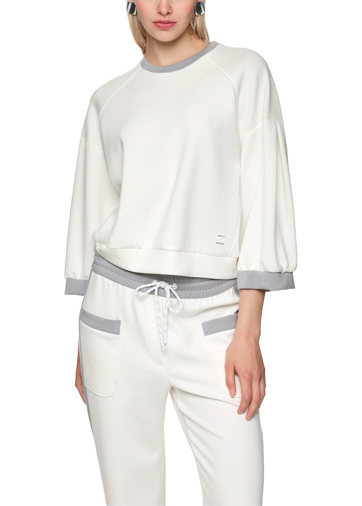 Woman wearing a white and gray outfit on a white background
