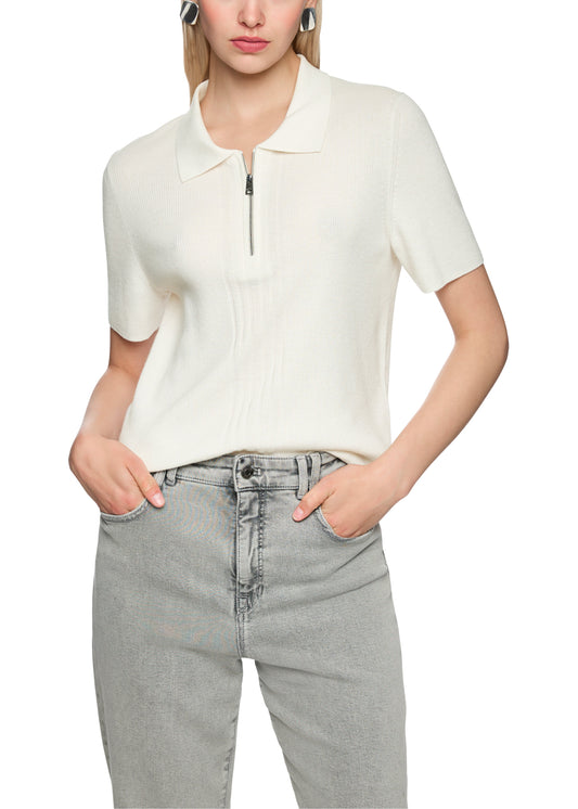 Person wearing a white short-sleeve top with a zipper and gray jeans on a white background