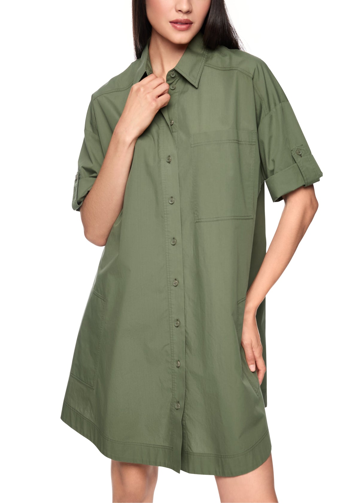 Woman wearing a green shirt dress on a white background