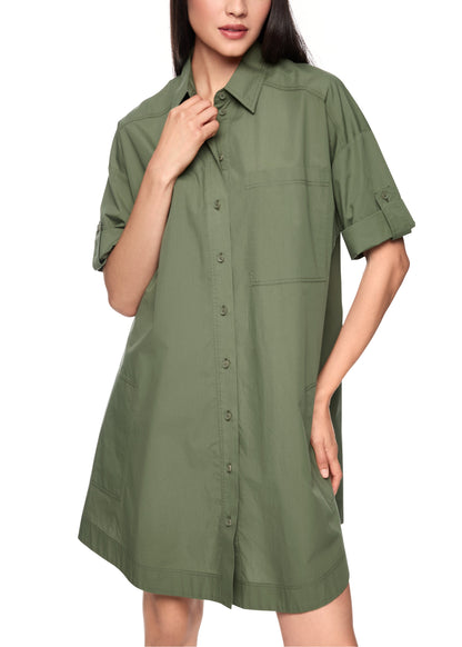 Woman wearing a green shirt dress on a white background