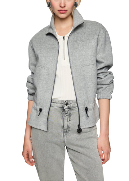 Person wearing a gray jacket and pants on a white background