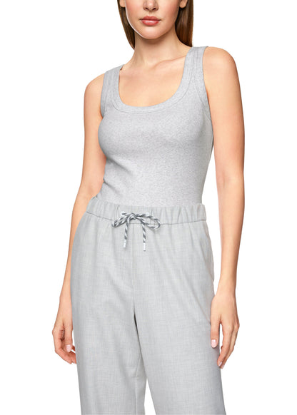 Woman wearing a gray sleeveless jumpsuit on a white background