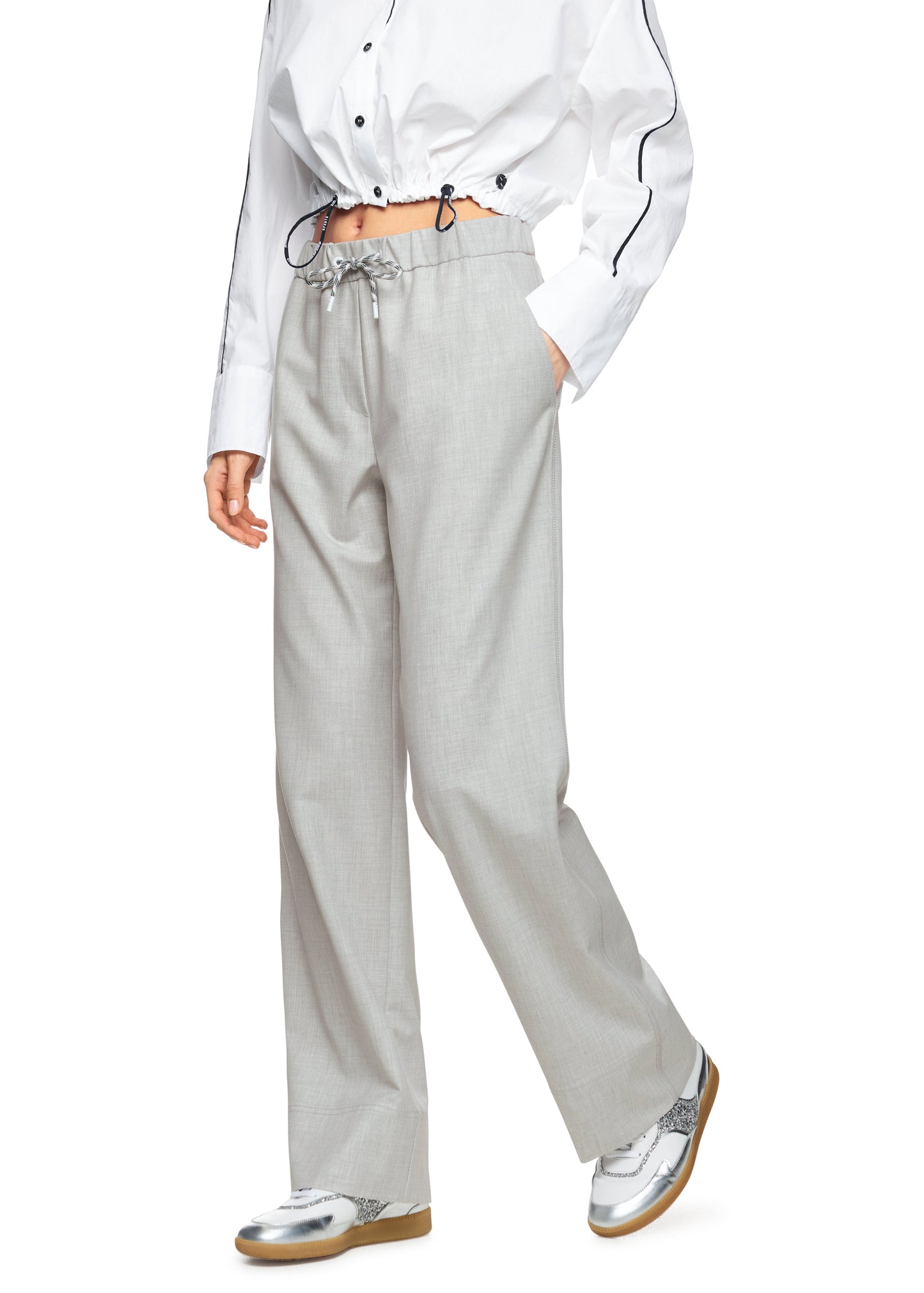 Person wearing a white shirt and light gray pants on a white background