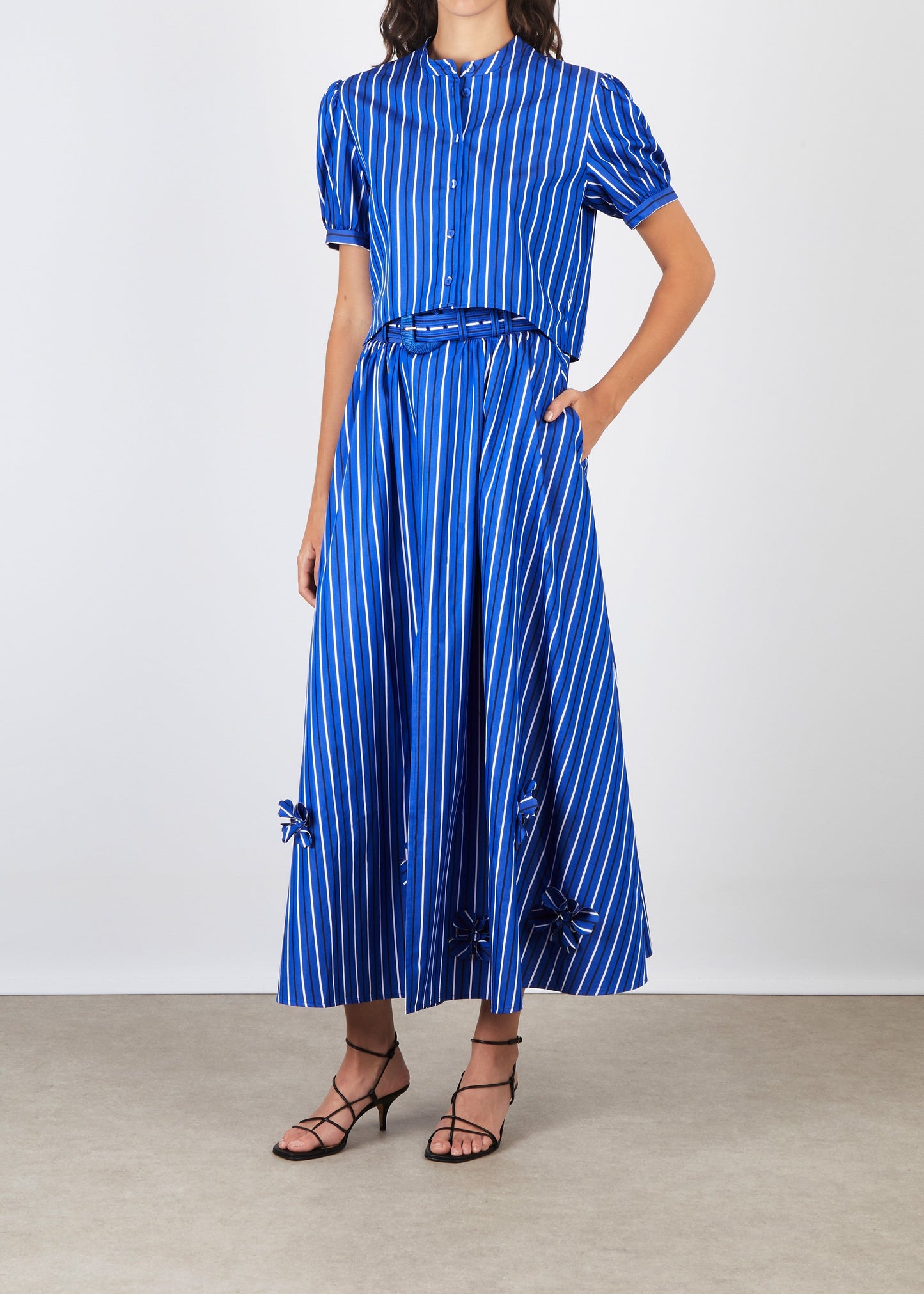 Woman wearing a blue and white striped dress on a plain background