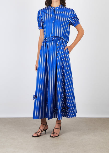 Woman wearing a blue and white striped dress on a plain background