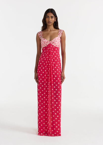 Woman wearing a pink polka dot dress on a white background