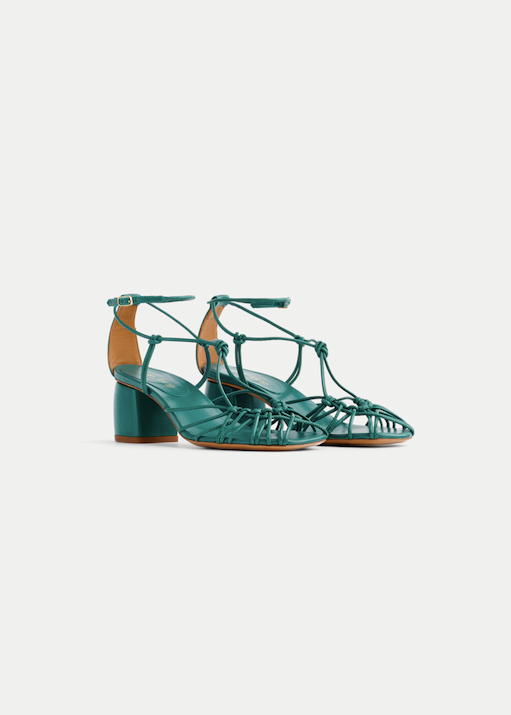 Teal high-heeled shoes with strappy design on a white background