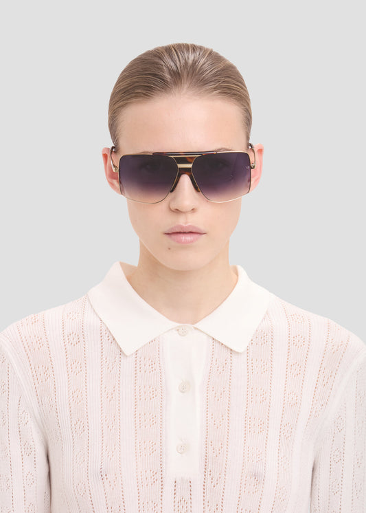 Person wearing sunglasses with a plain background