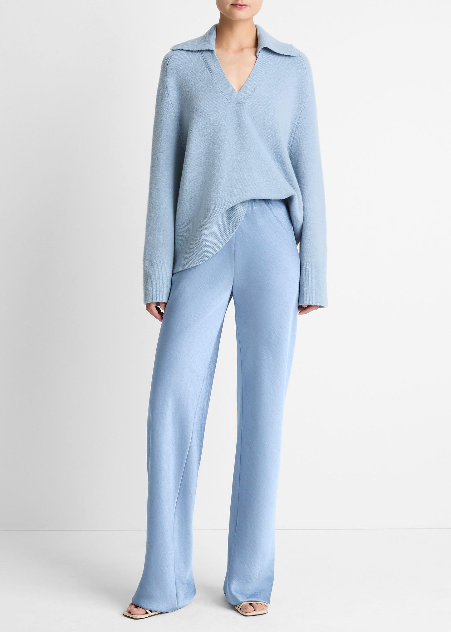 Person wearing a light blue outfit with a matching top and pants on a white background