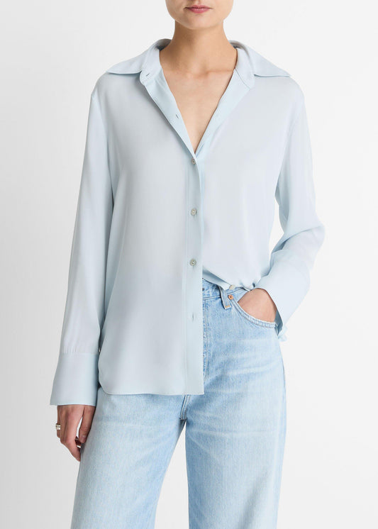 Person wearing a light blue shirt and jeans on a plain background