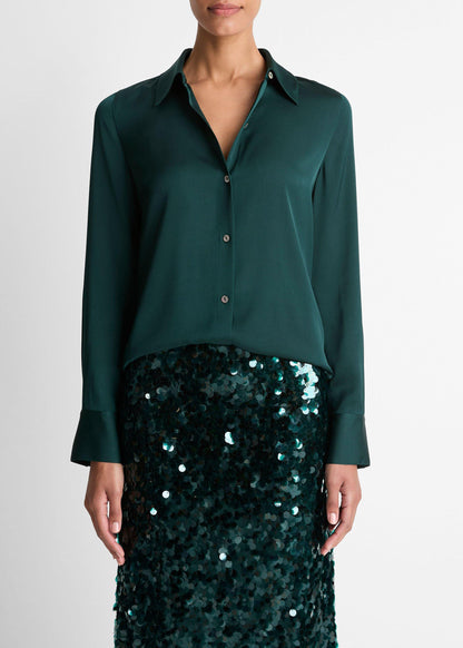 Person wearing a dark green shirt with a sequined skirt on a white background
