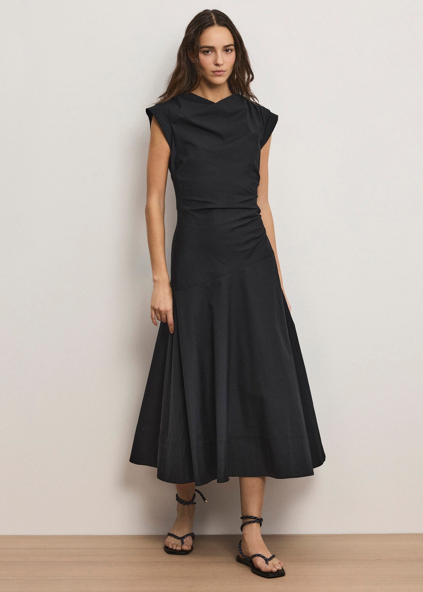 Woman wearing a black dress against a plain background
