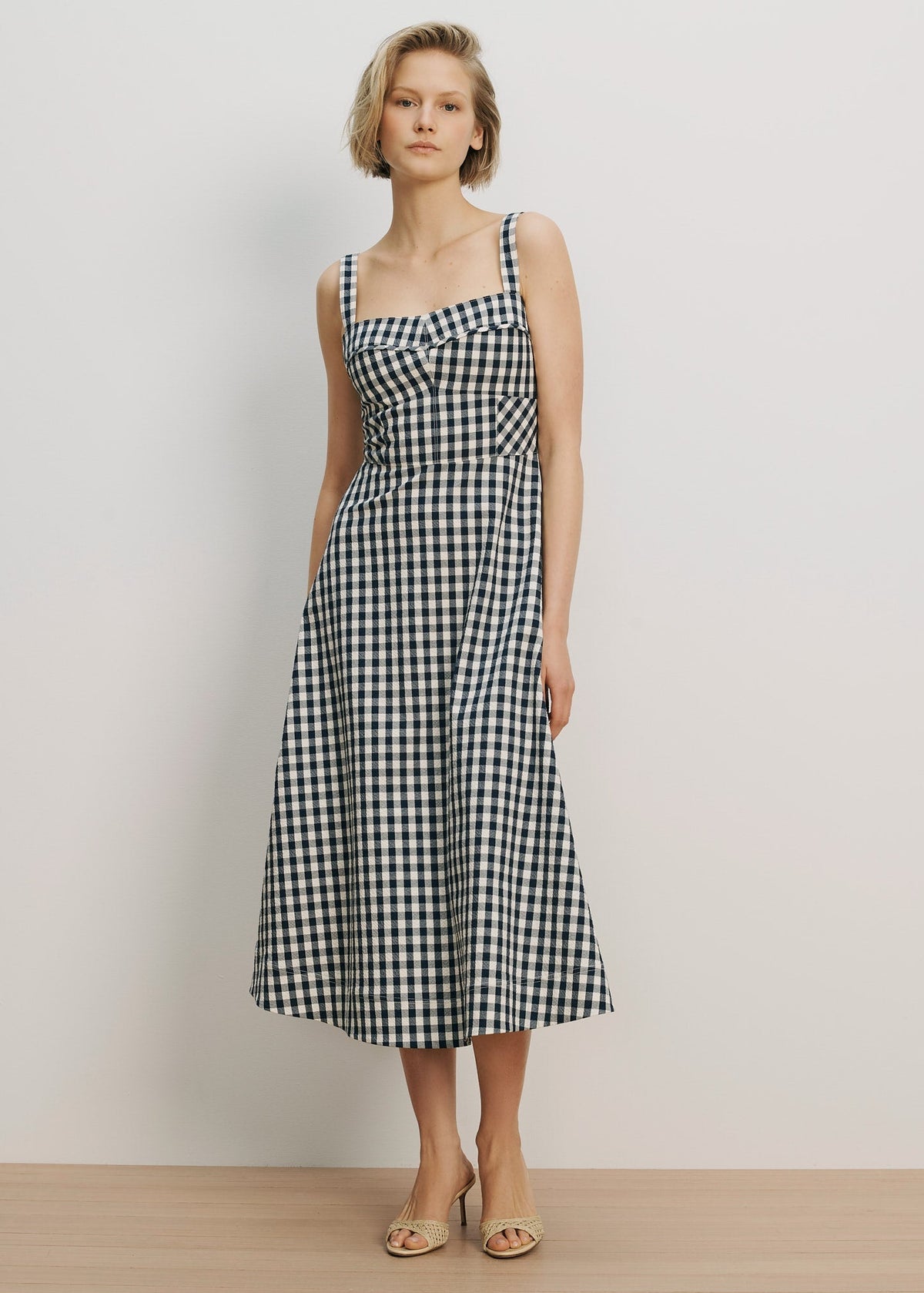 Woman wearing a black and white checkered dress against a plain background