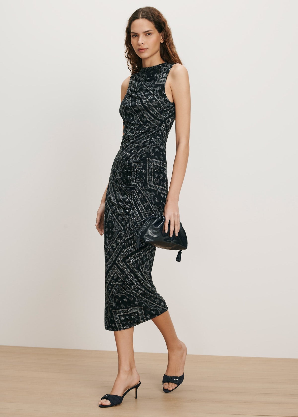 Woman wearing a black patterned dress on a plain background