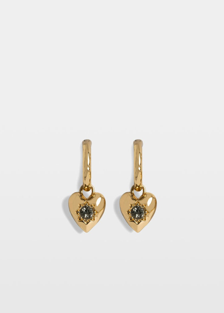 Gold heart-shaped earrings with gemstones on a light gray background