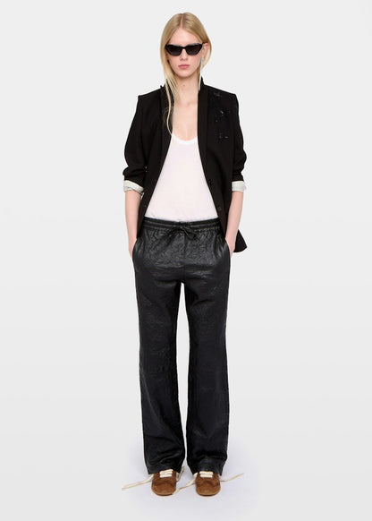 Person wearing a black blazer, white top, and black pants on a white background