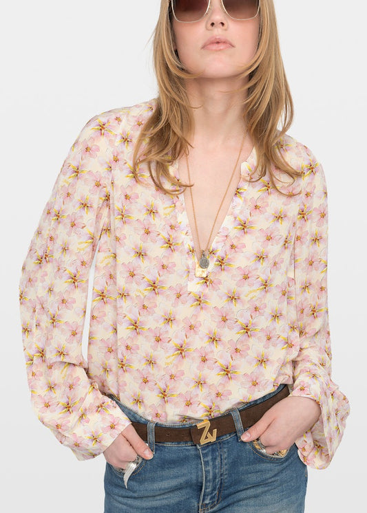 Woman wearing a floral blouse with a plain background