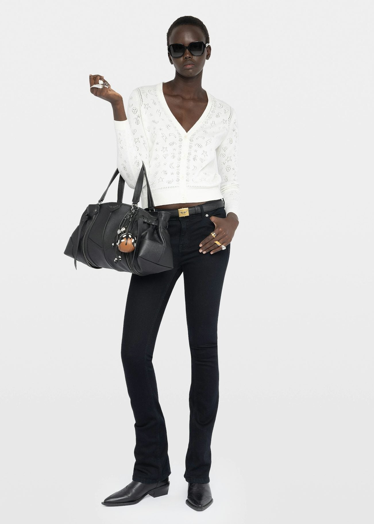 Woman holding a black handbag against a white background