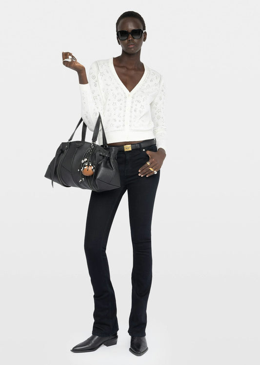 Woman holding a black handbag against a white background