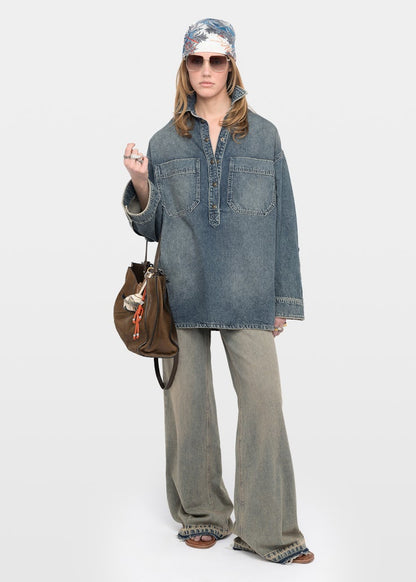 Person wearing a denim jacket and wide-leg jeans on a white background