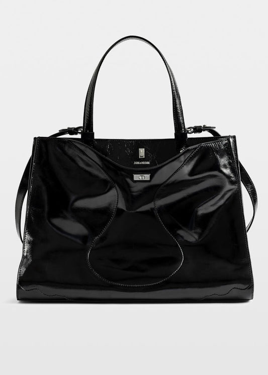Black patent leather handbag on a light gray background