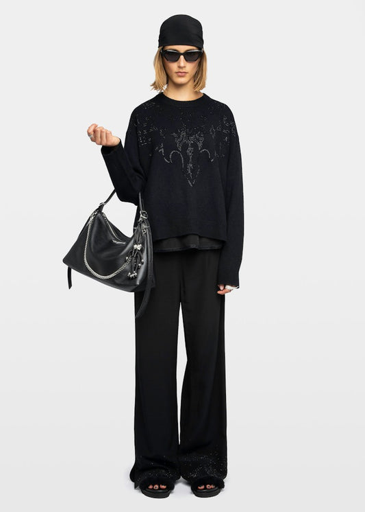 Person wearing a black outfit with a clear handbag on a white background