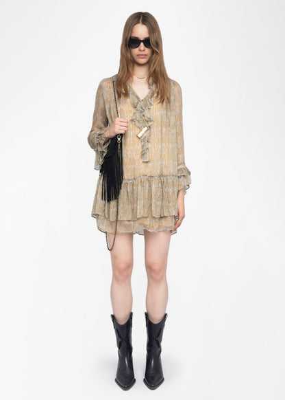 Woman wearing a patterned dress with black boots on a white background