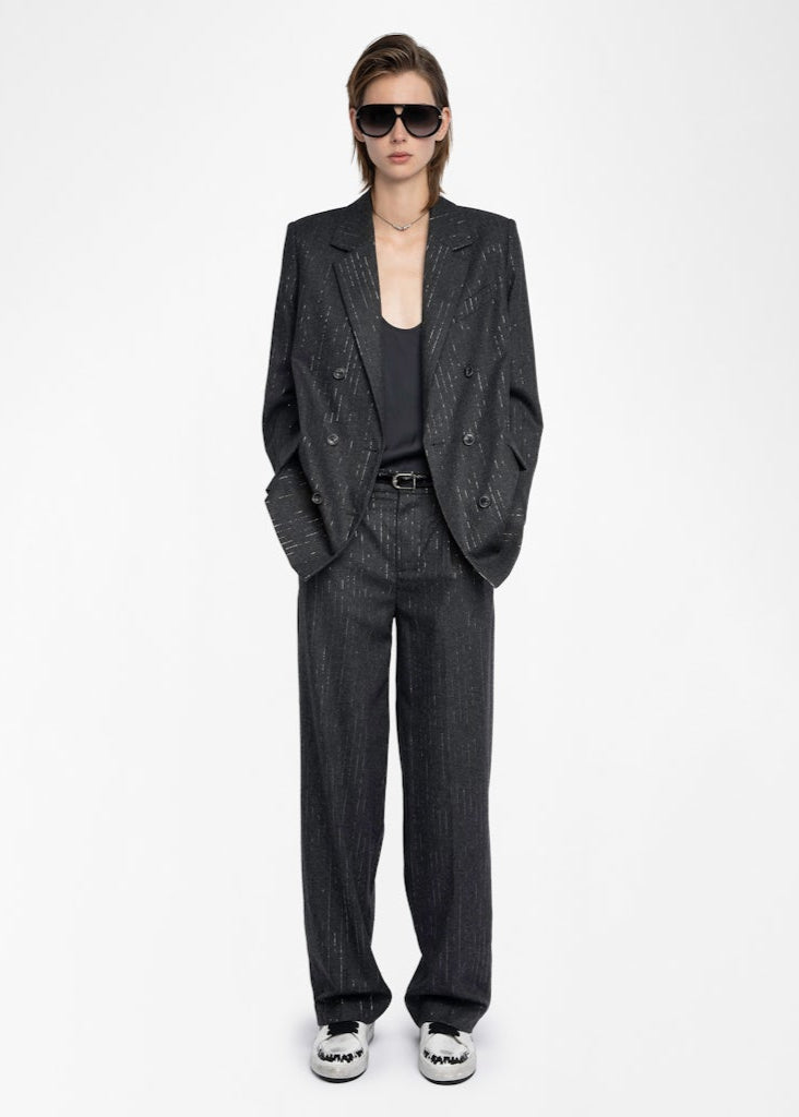 Person wearing a dark gray suit with sunglasses on a white background