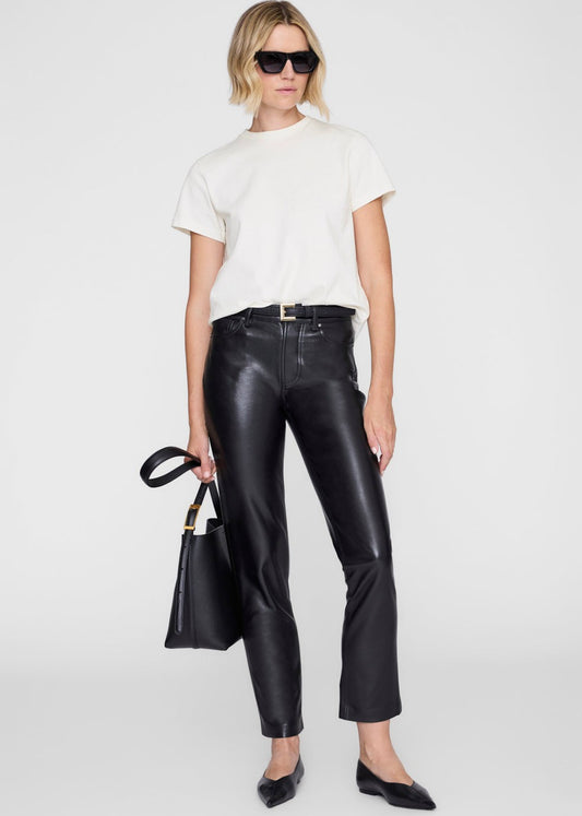 Person wearing a white t-shirt and black leather pants with sunglasses and a handbag on a white background
