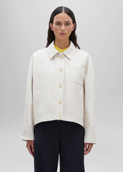 Person wearing a white jacket on a plain background