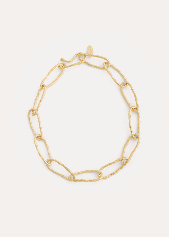 Gold chain bracelet on a light gray background