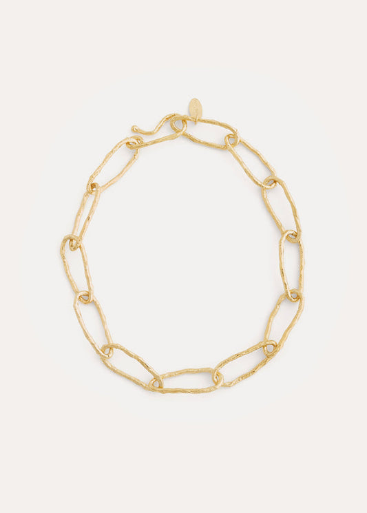 Gold chain bracelet on a light gray background