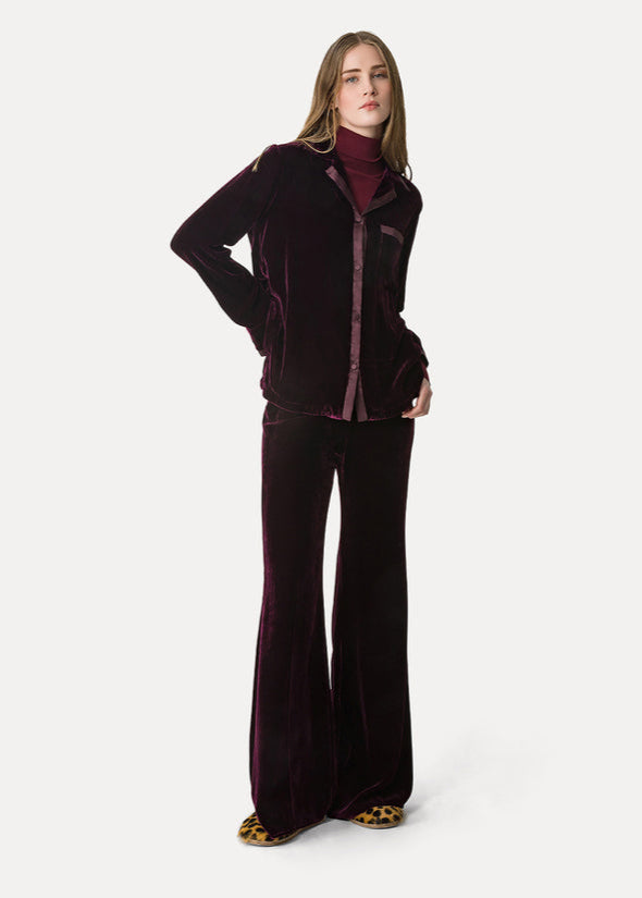 Woman wearing a dark purple outfit on a white background