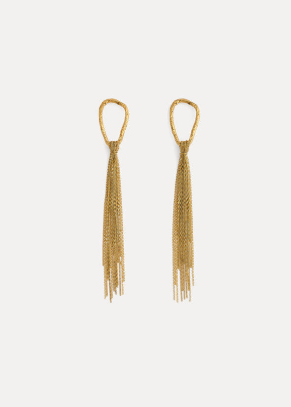 Gold tassel earrings on a light gray background