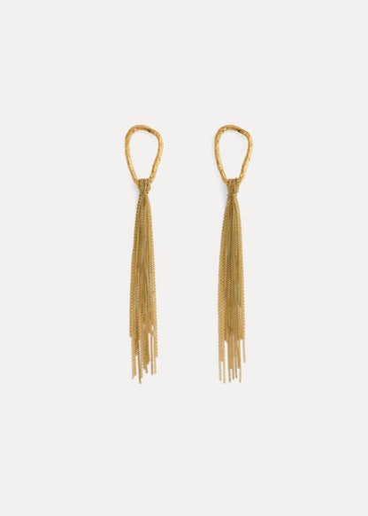 Gold tassel earrings on a light gray background