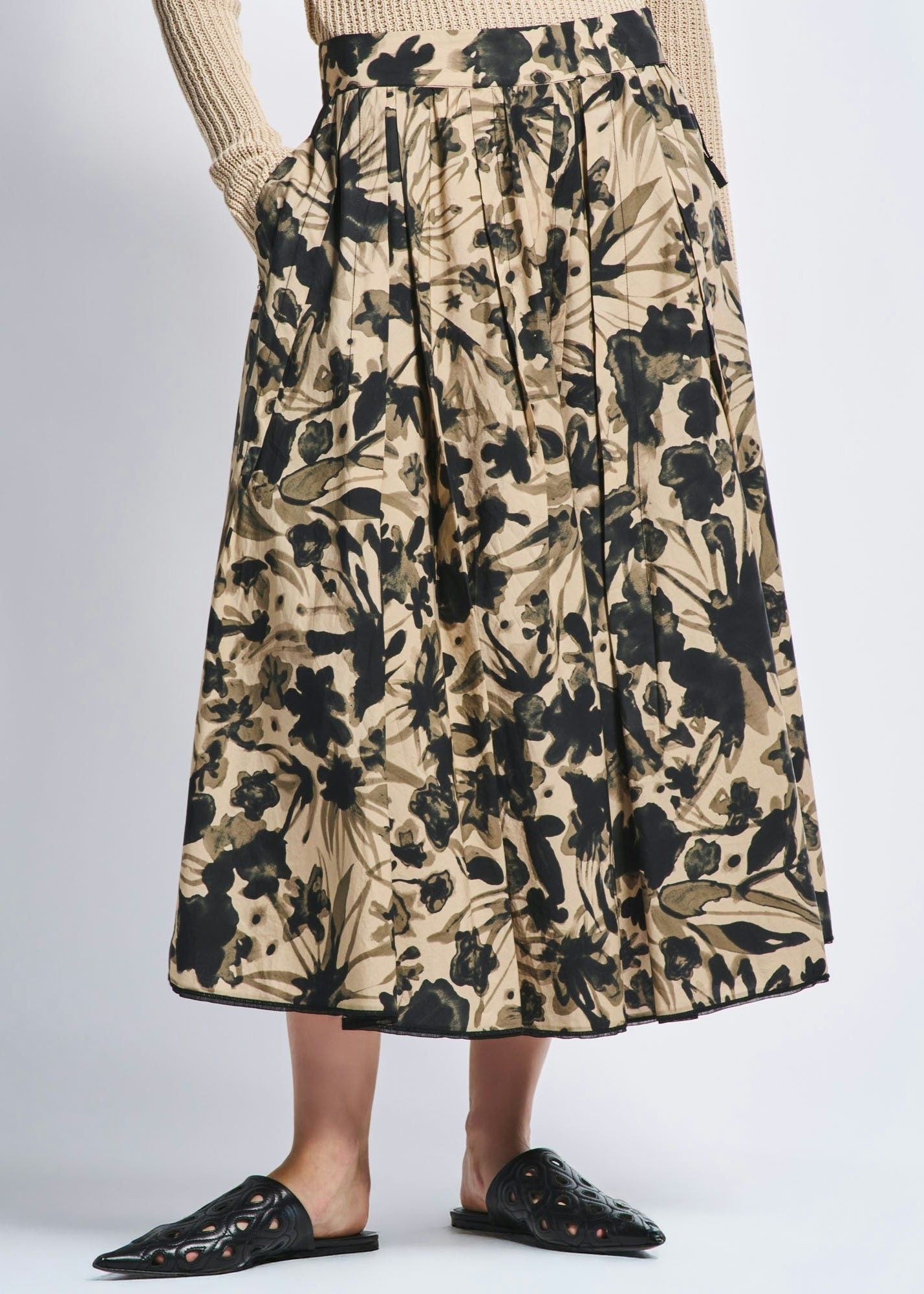 Floral patterned skirt worn by a person on a plain background