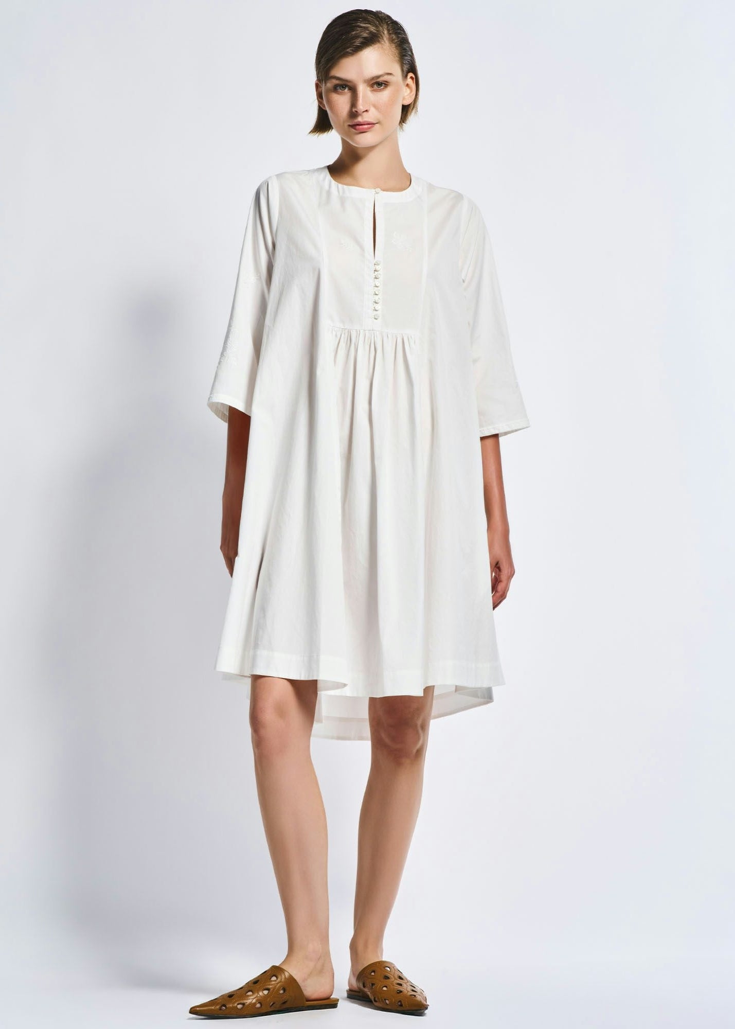 Woman wearing a white dress on a plain background