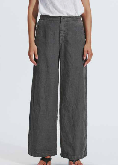 Person wearing dark gray wide-leg pants on a white background