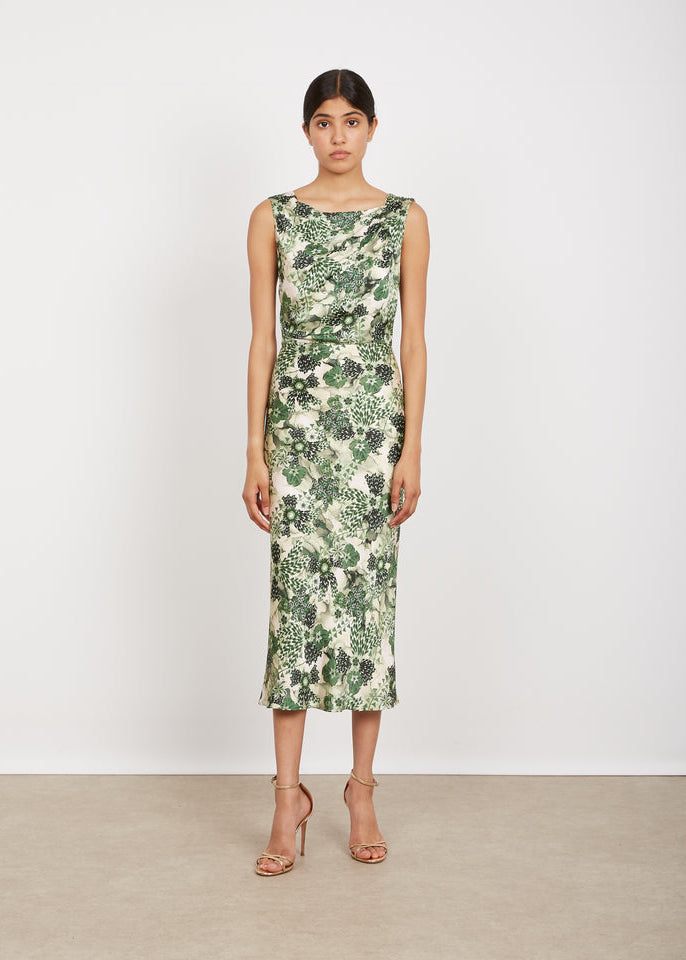 Woman wearing a green floral dress against a white background