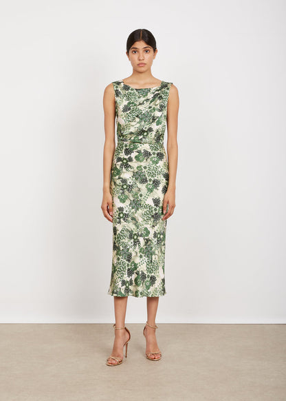 Woman wearing a green floral dress against a white background