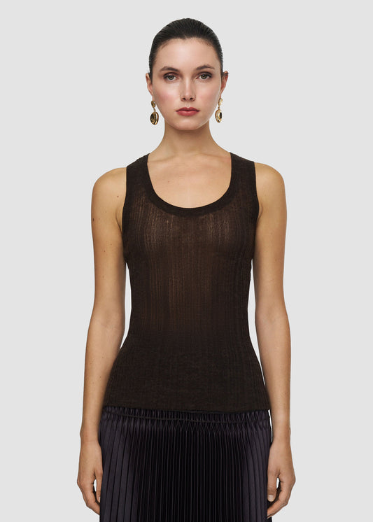 Woman wearing a black sleeveless top against a plain background