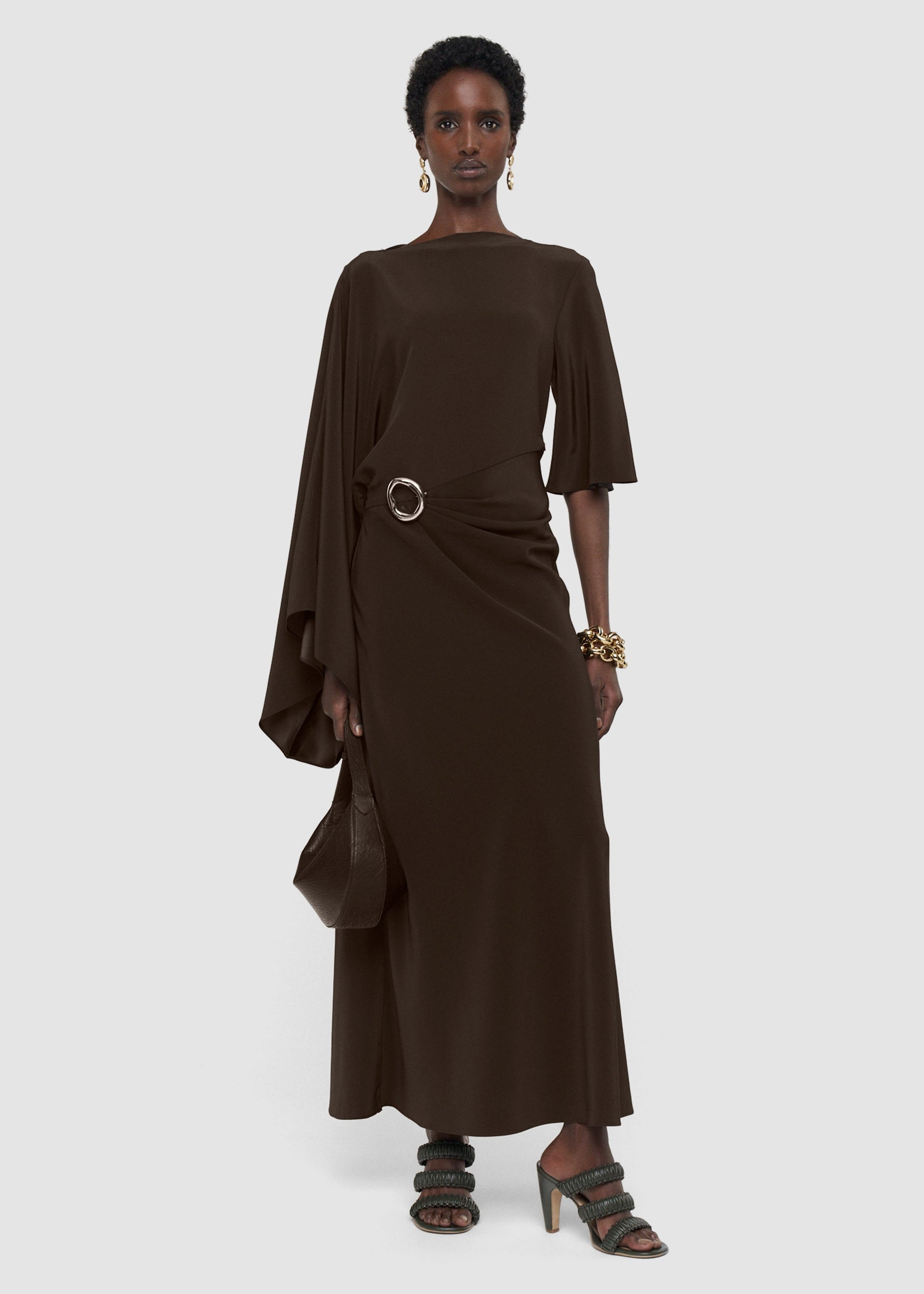 Woman wearing a brown dress with a belt on a white background