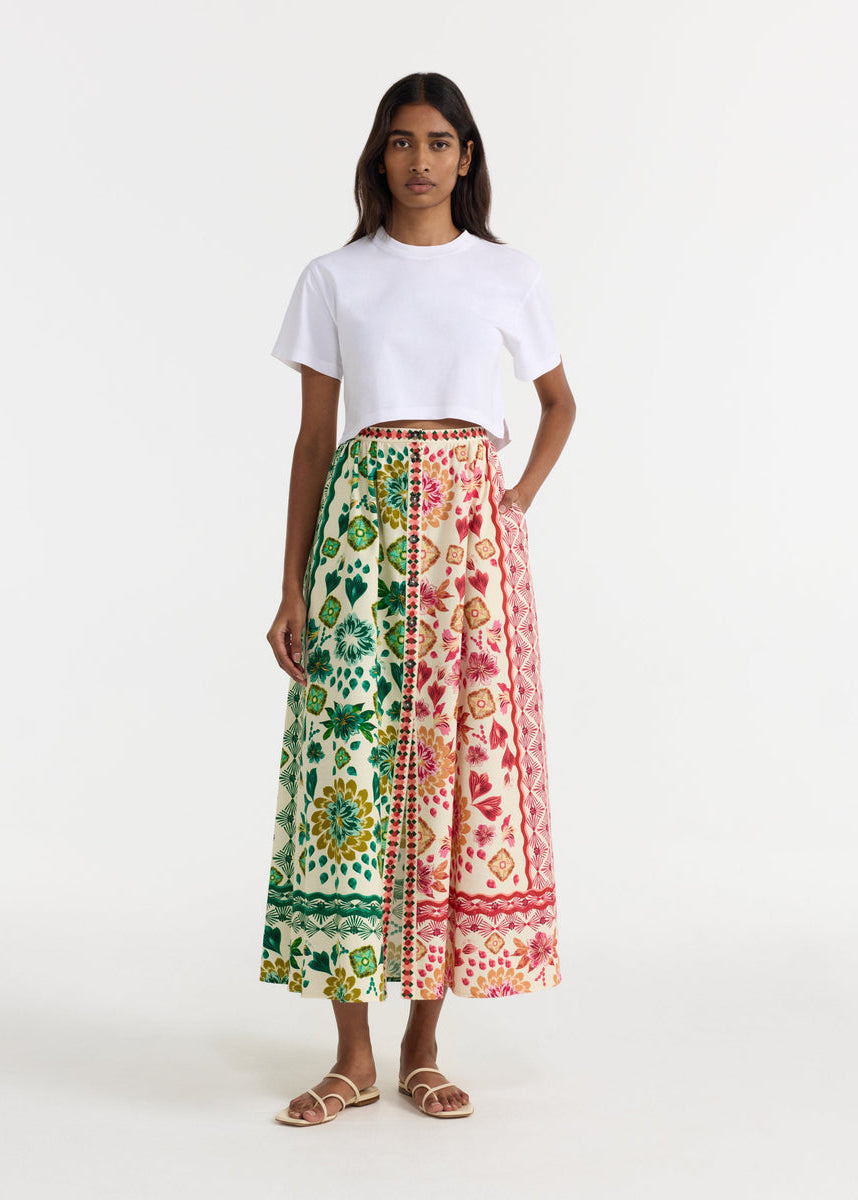 Woman wearing a white t-shirt and a colorful patterned skirt on a white background