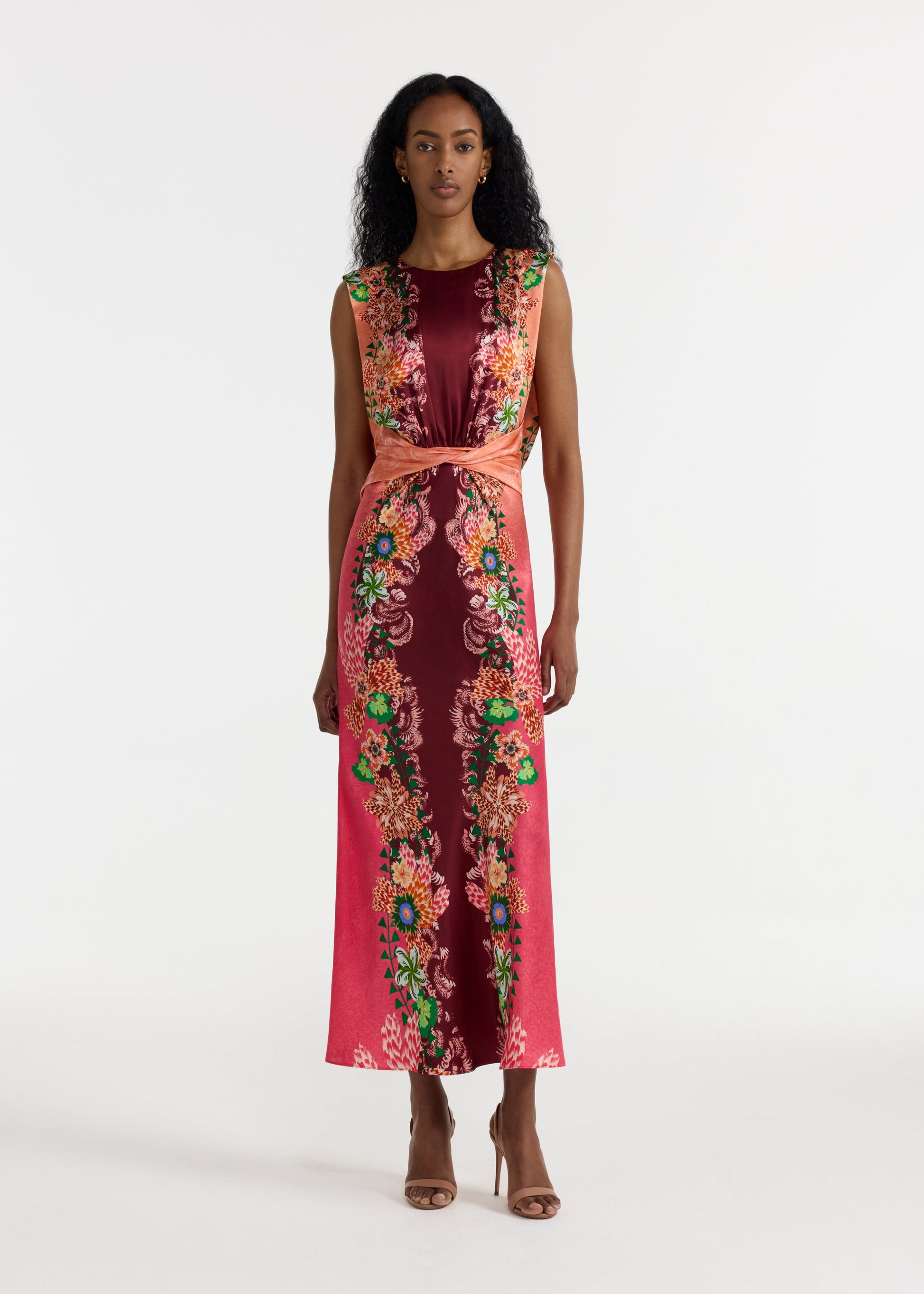 Woman wearing a sleeveless dress with floral patterns on a white background